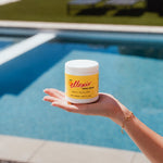 Ellexir Manila Mango Energy jar in hand by the pool